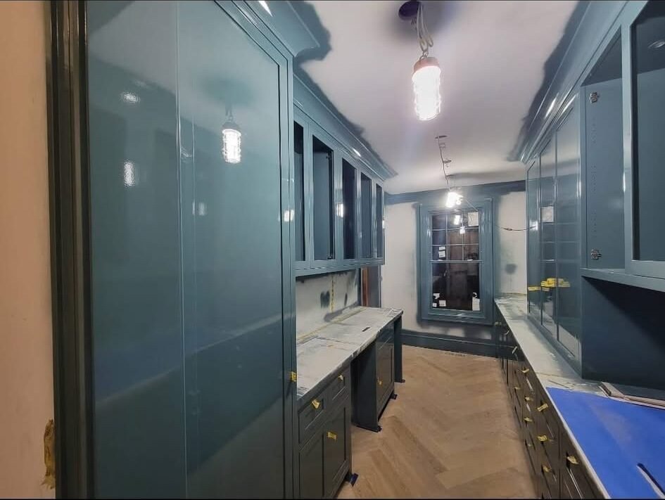 Glossy teal painted butler's pantry cabinetry in a Fairfield County home