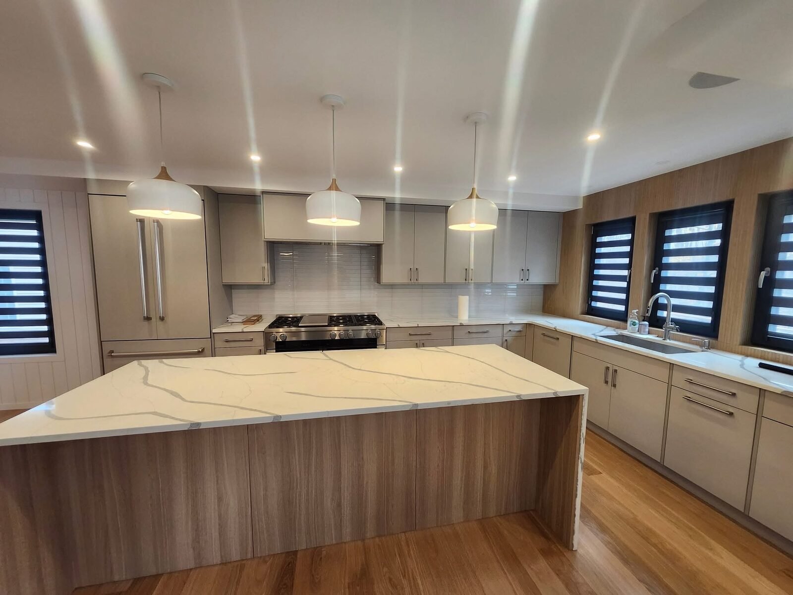 Freshly painted modern kitchen with taupe cabinets and pendant lights in a Greenwich CT home