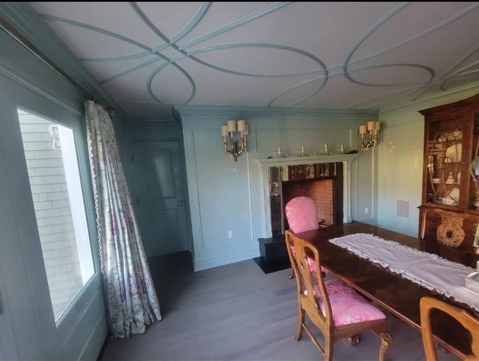 Sage-blue paneled dining room with painted decorative ceiling molding in a Ridgefield CT home