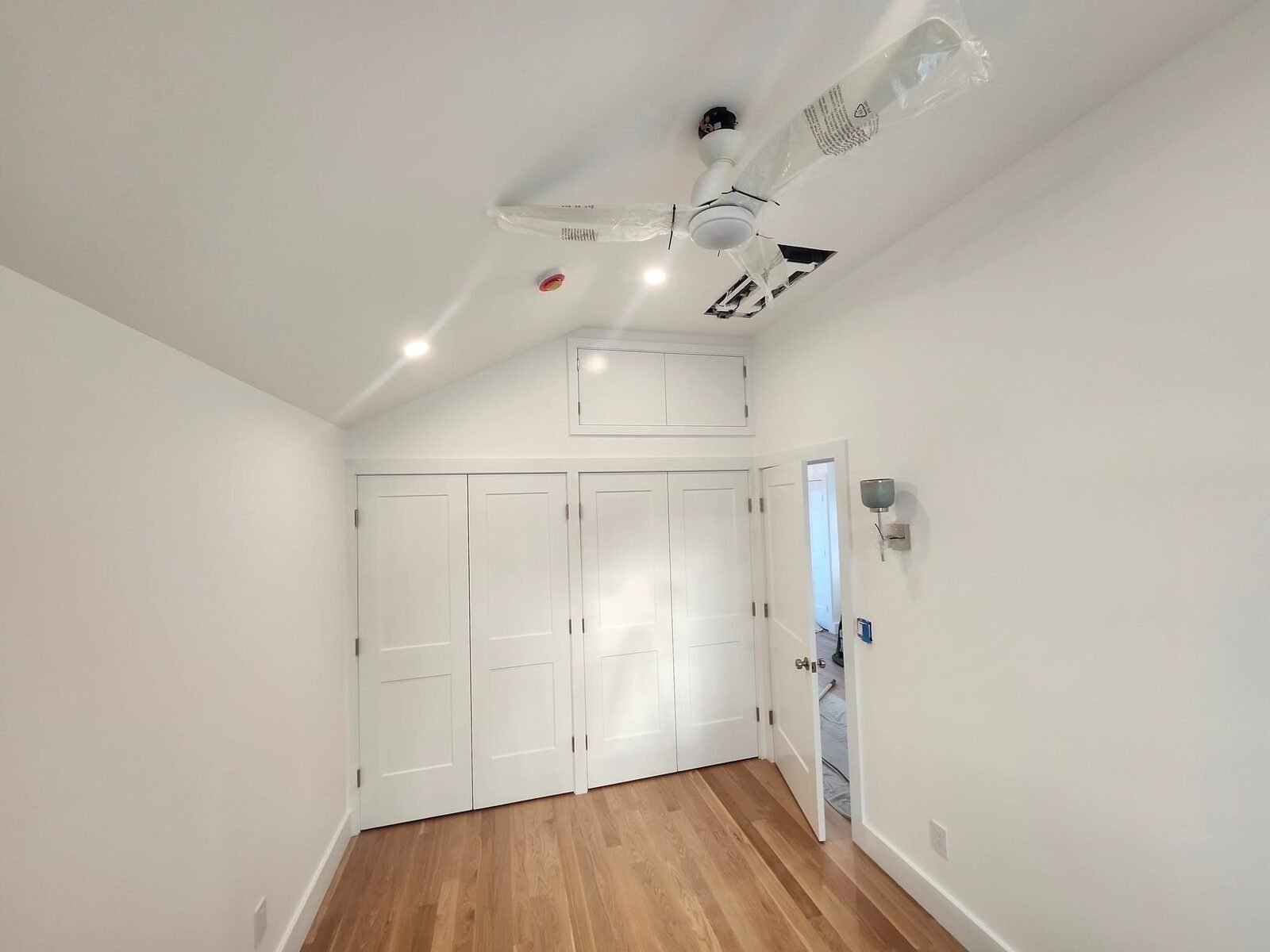 Bedroom with freshly painted white walls and closet doors in a Trumbull CT home