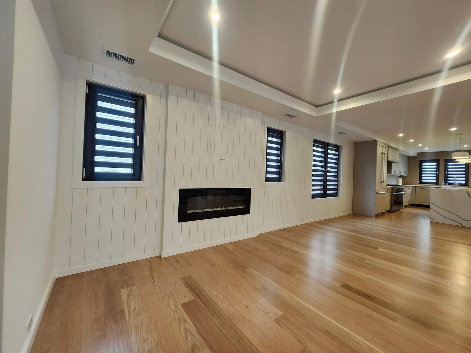 Painted white shiplap fireplace wall in an open living area of a Wilton CT home